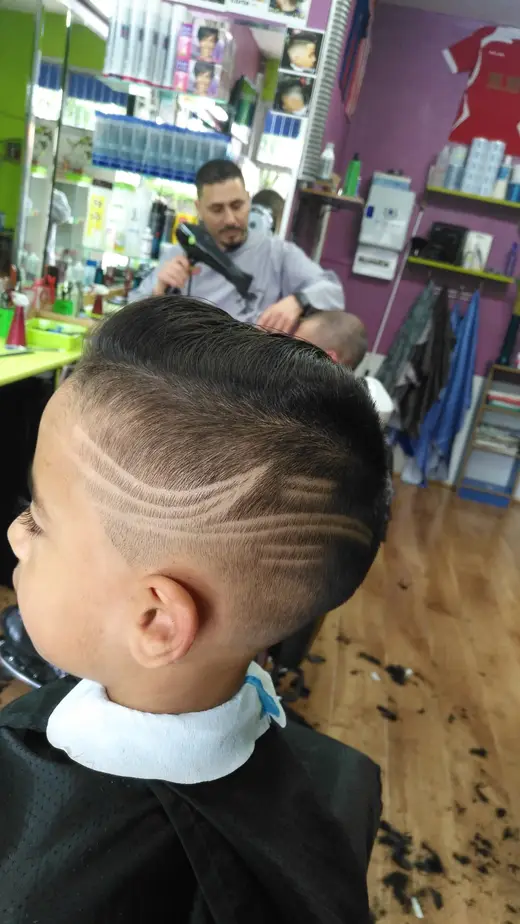 Corte de niño con diseño de líneas en el lateral · Barbería Los Primos Tarik, Getafe