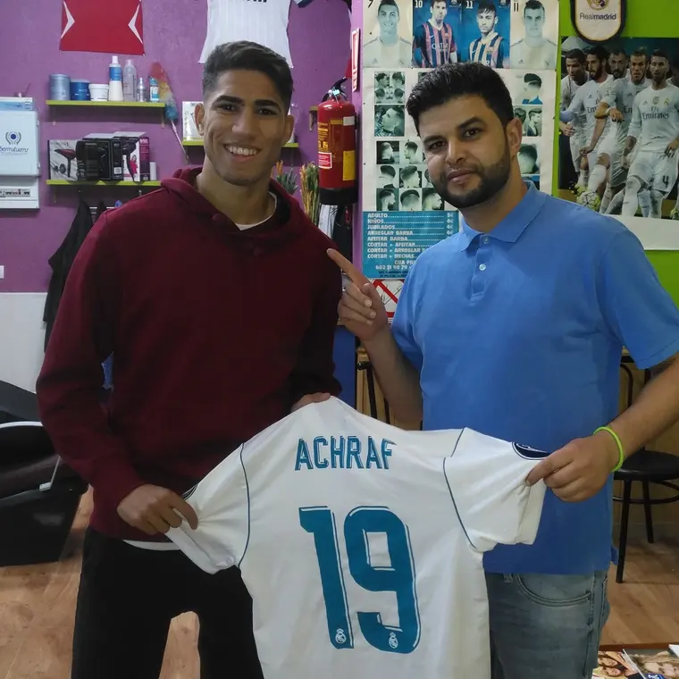 Achraf Hakimi y un barbero de Los Primos Tarik con una camiseta del Real Madrid